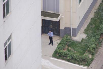 5月13日下午，记者看到监区内一名民警用手持设备通话。