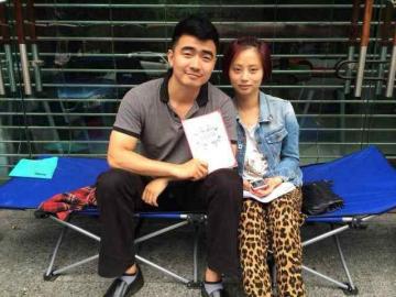 一对新人19日晚便自带行军床到成都高新区婚姻登记处门前，坐等“520”。华西都市网杨婕摄