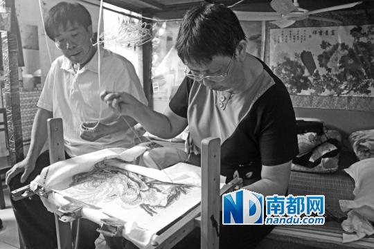 李光琼正在绣新的十字绣作品，旁边是丈夫沈忠梁。南都记者王卫摄