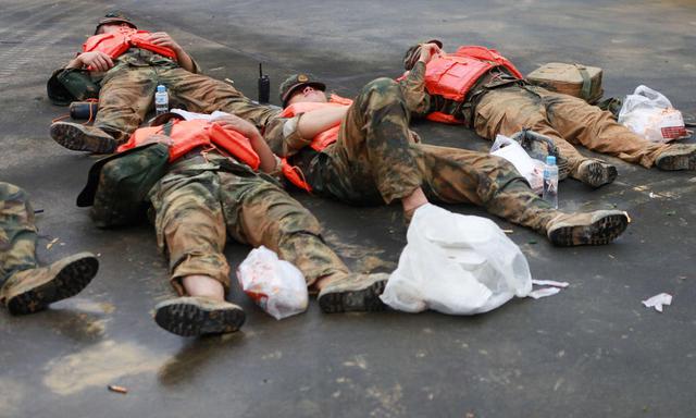 高清:武警暴雨搜救后席地而睡 浑身裹满泥浆