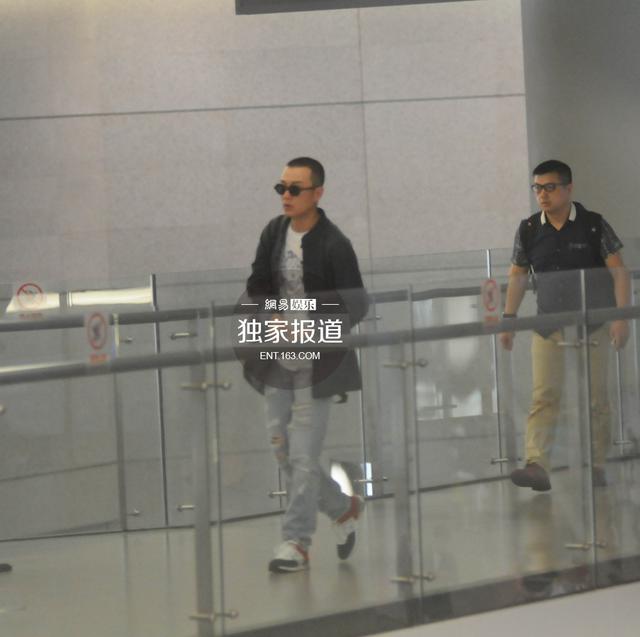 文章板寸发型回沪 快步出机场忙抽烟