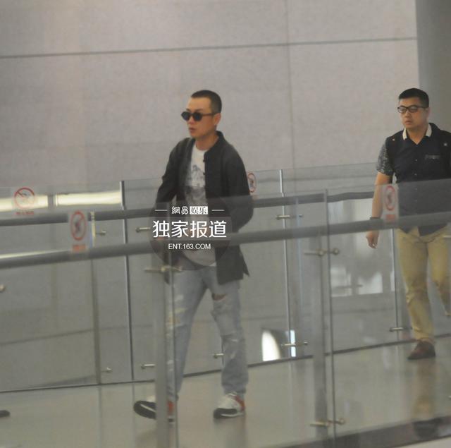 文章板寸发型回沪 快步出机场忙抽烟